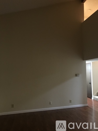 A room with beige walls and wooden flooring.