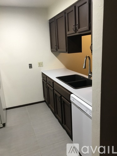 A kitchen with brown cabinets and a white dishwasher.