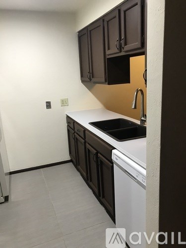 A kitchen with brown cabinets and a white dishwasher.