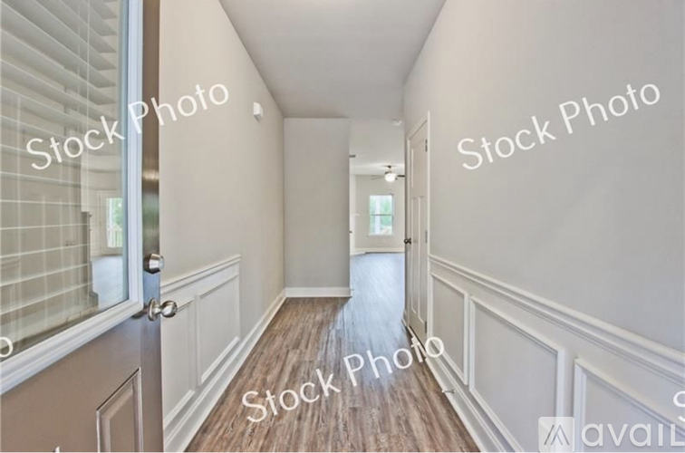 A hallway with wooden floors and white walls.