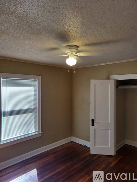 A room with a ceiling fan and a door.