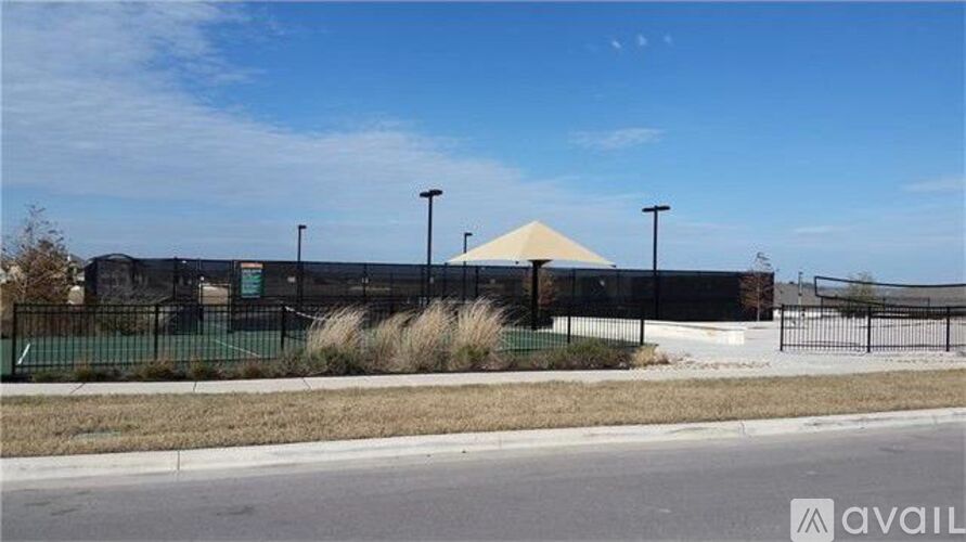 A building with a black fence and a white canopy is visible.