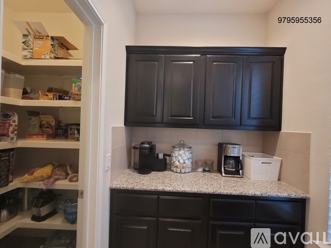 A kitchen with black cabinets and a white countertop.