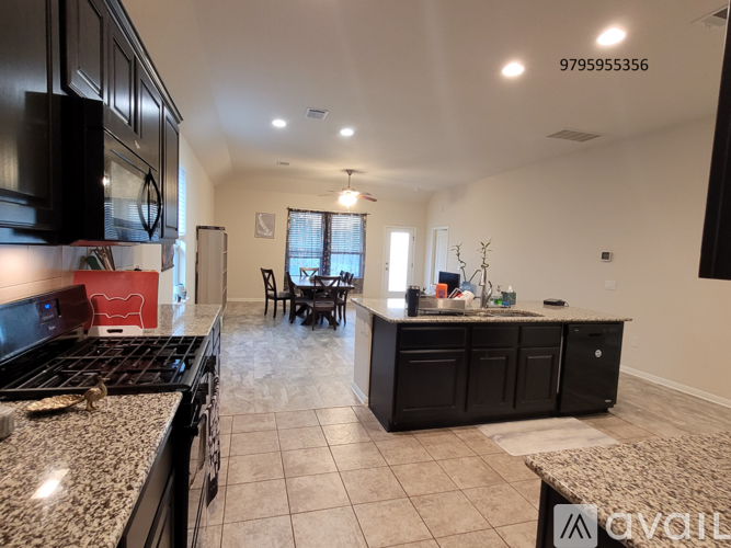 A kitchen with black cabinets and granite countertops.