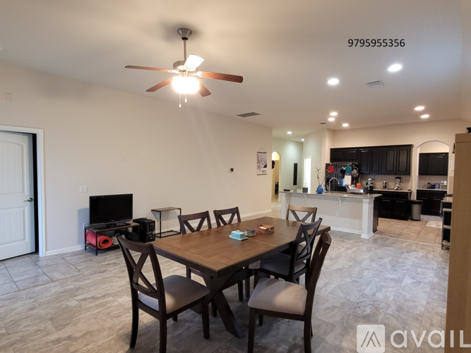 A dining room with a table set for four and a ceiling fan.