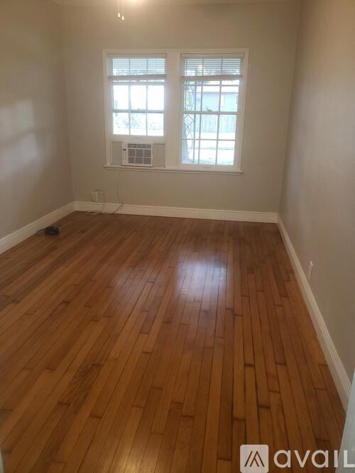 A room with wooden flooring and a window.