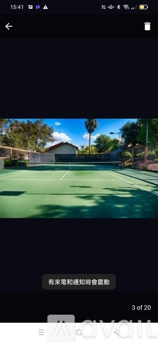 A tennis court surrounded by a fence and trees.