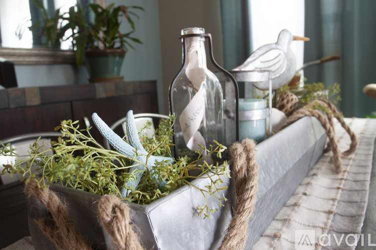 A decorative metal box with plants and a bottle on top.