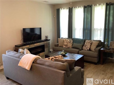 A living room with a grey couch, a coffee table, and a television.