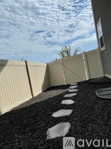 A gravel path with stepping stones leads to a building.