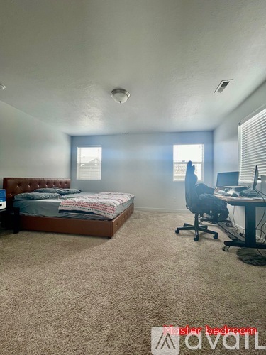 A bedroom with a bed, desk, and chair.