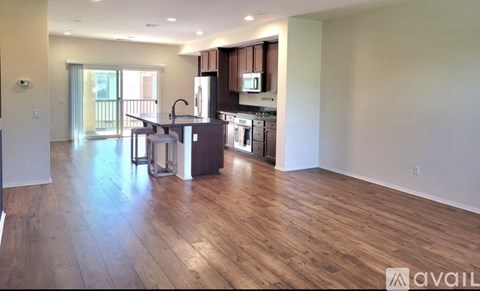 A kitchen with wooden floors and a refrigerator with a digital display.