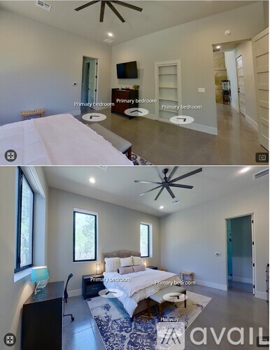 A bedroom with a bed, a desk, and a ceiling fan.