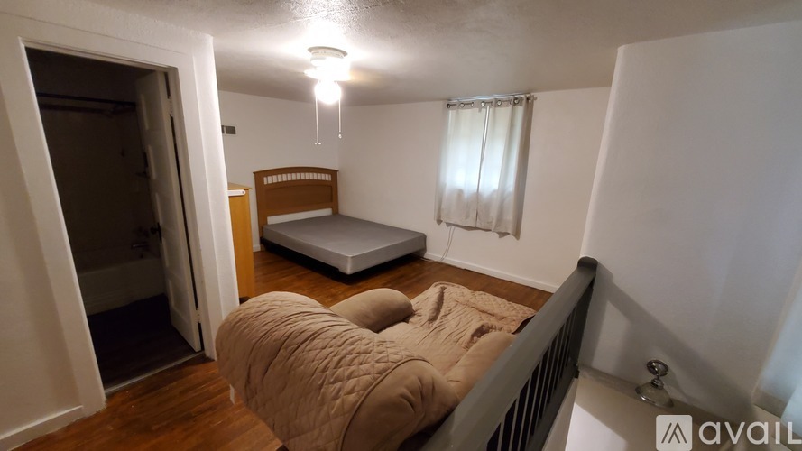 A bedroom with a bed, dresser, and window.