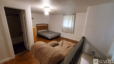 A bedroom with a bed, dresser, and window.