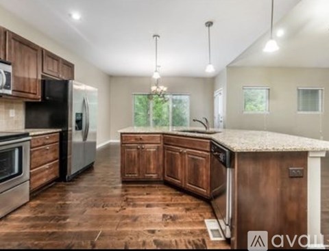 A kitchen with wooden cabinets and a granite countertop.