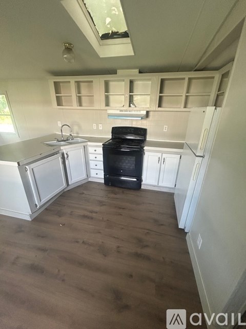 A kitchen with a black oven and white cabinets.