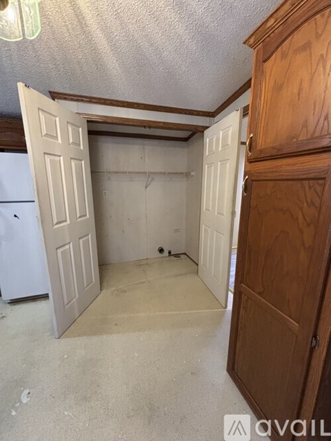 A kitchen with a white refrigerator and a wooden cabinet.