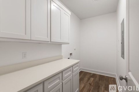 A kitchen with white cabinets and a white counter top.