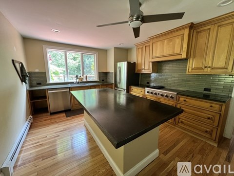 A kitchen with wooden cabinets and a black countertop.