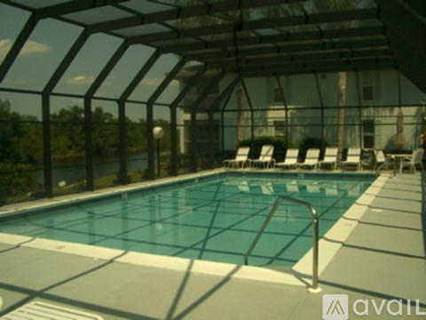 A pool with chairs and a glass ceiling.