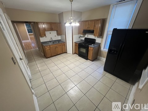 A kitchen with black appliances and wooden cabinets.