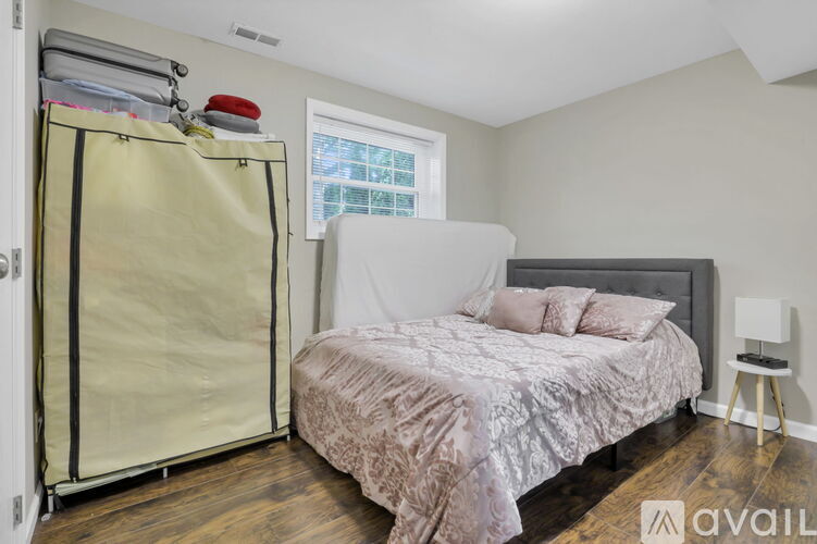 A bedroom with a bed, a window, and a small table.