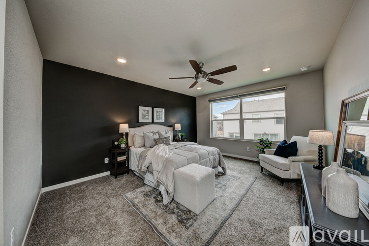 A bedroom with a large bed and a ceiling fan.