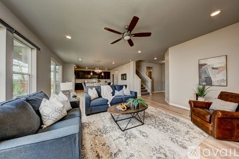 A living room with a blue couch and a brown leather chair.