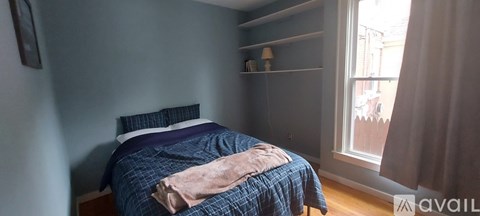 A bedroom with a bed and a window.