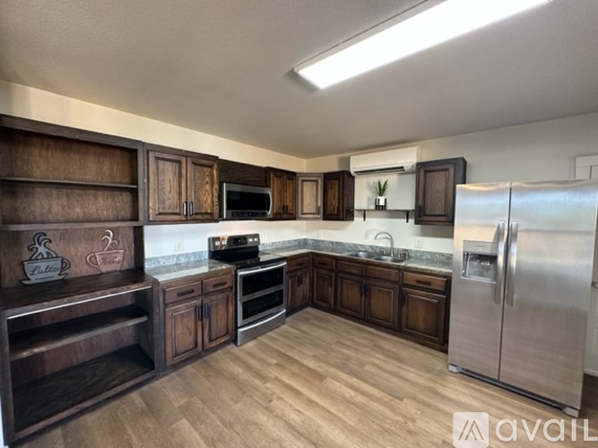 A kitchen with wooden cabinets and a stainless steel refrigerator.
