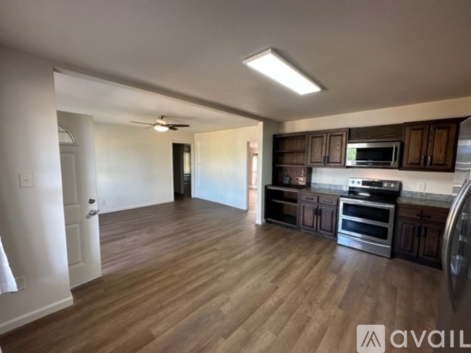 A kitchen with wooden floors and stainless steel appliances.