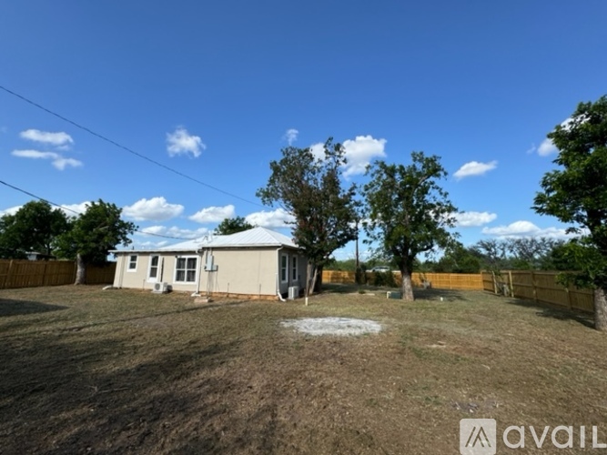 A house with a yard and trees in the background.