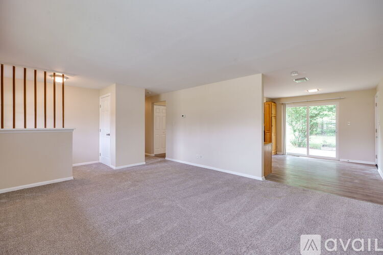 A spacious room with a carpeted floor and a large window.