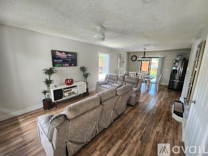 A living room with a large couch and a television on the wall.