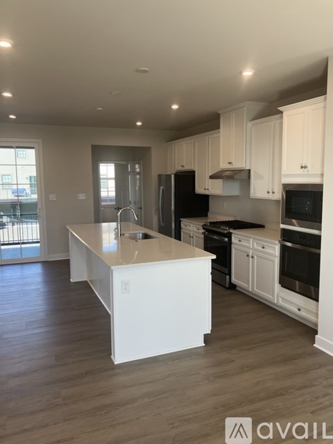 A kitchen with white cabinets and a large island.