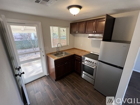 A kitchen with a refrigerator, stove, and sink.