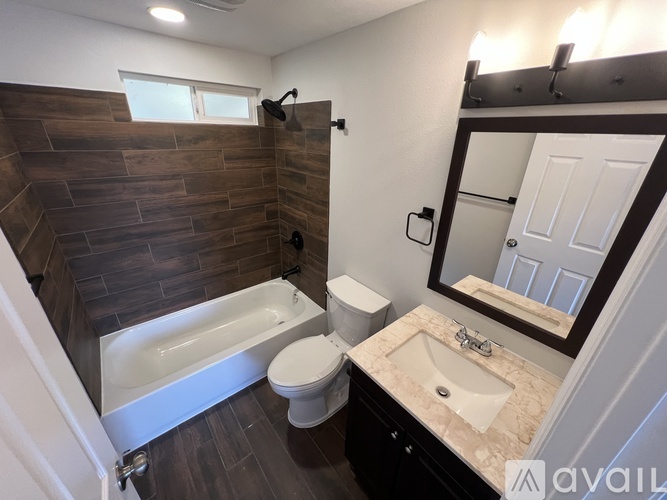 A bathroom with a wooden wall and a white toilet.