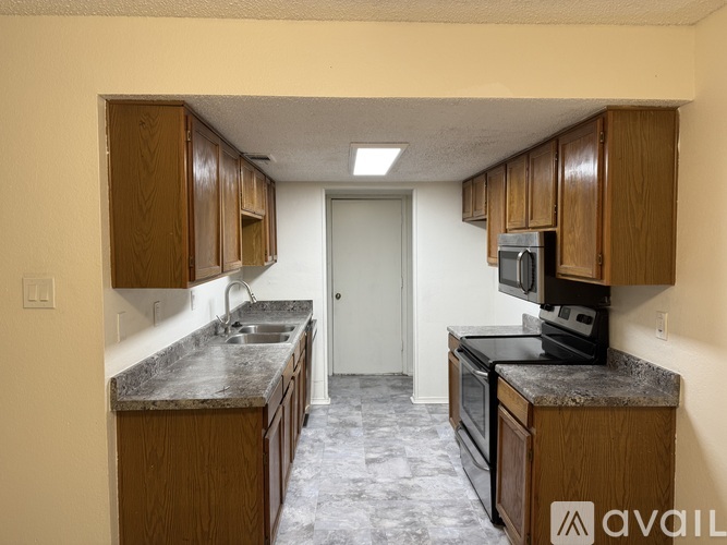 A kitchen with wooden cabinets and granite countertops.