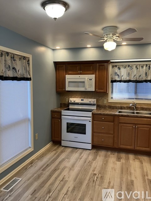 A kitchen with wooden cabinets and a white oven.