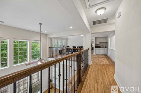 A spacious room with a balcony and a view of greenery outside.