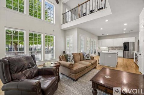 A living room with a brown leather chair and a brown sofa.