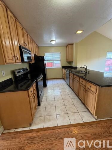 A kitchen with wooden cabinets and black appliances.