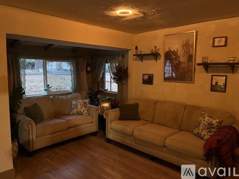 A living room with two couches and a table with a vase of flowers on it.