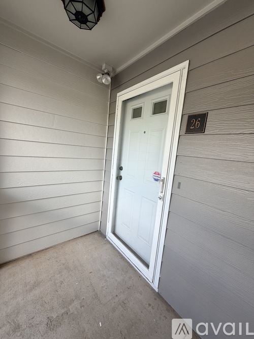 A white door with a number 26 on the wall above it.