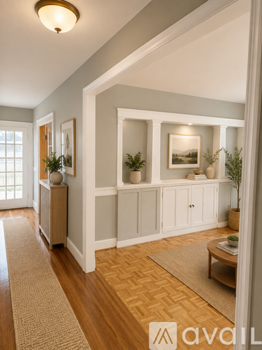 A hallway with a rug and a cabinet with a plant on top.