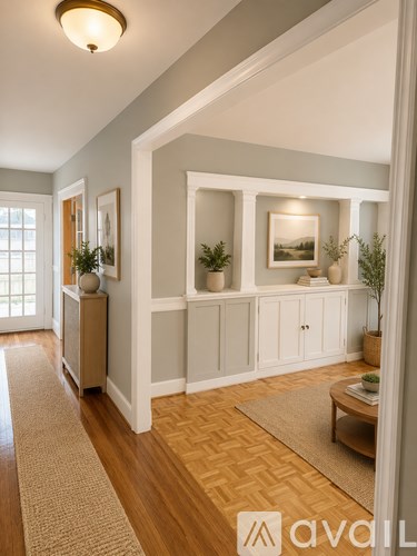 A hallway with a rug and a cabinet with a plant on top.