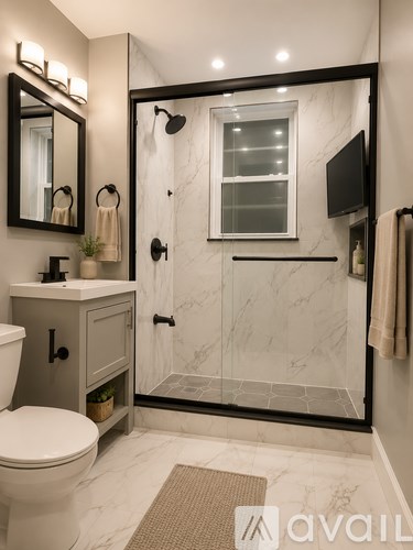 A bathroom with a marble floor and a walk-in shower.