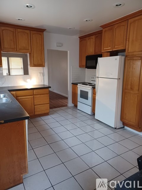 A kitchen with wooden cabinets and white appliances.