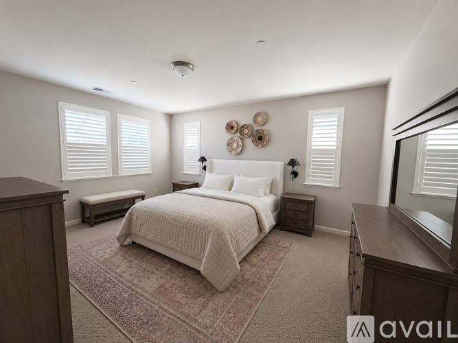 A bedroom with a bed, nightstand, and window with blinds.